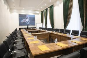 una sala riunioni con tavoli in legno e sedie nere di Hotel Marwa Tashkent Pool&Spa a Tashkent