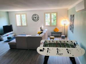 ein Wohnzimmer mit einem Sofa und einem Tisch in der Unterkunft Villa 3* piscine vue montagne proche mer & Espagne in Le Boulou