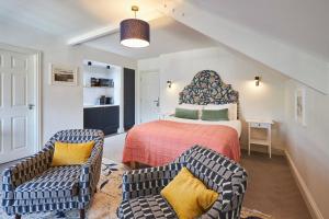 a bedroom with a bed and two chairs at Arlington House Hotel - Luxurious Self Check-In Ensuite Rooms in the Centre of Wooler in Wooler