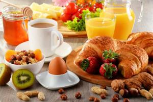 - une table avec petit-déjeuner composé de croissants, de fruits et de jus dans l'établissement Kay Sun Hotel, 