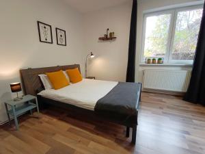 a bedroom with a bed with orange pillows and a window at PIF Apartments Sadoveanu in Braşov