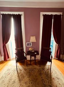 uma sala de estar com cortinas vermelhas e uma mesa e cadeiras em The Dragonfly Guest House em Nova Orleans