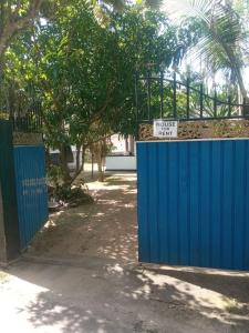 a blue gate with a sign on top of it at DAMMI VILLA in Hikkaduwa