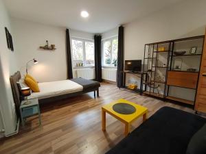 a living room with a bed and a yellow stool at PIF Apartments Sadoveanu in Braşov