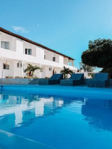 a swimming pool in front of a building at Dlux Suites Baia Formosa in Baía Formosa