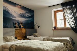 a bedroom with two beds and a painting on the wall at Alpen Lodge Premium Apartment in Mezzana