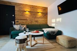 a living room with a green couch and a table at Alpen Lodge Premium Apartment in Mezzana