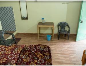Anoop Tourist Guest House, Phata في Phata: غرفة بسرير وطاولة وكراسي