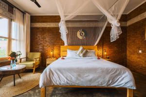 a bedroom with a large bed and a chair at Rafiki Retreat in Arusha