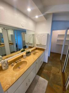 baño con 2 lavabos y espejo grande en Tranquil Beachfront Duplex-type Private House!, en Hauula
