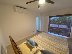 a bedroom with a bed and a large window at Tranquil Beachfront Duplex-type Private House! in Hauula