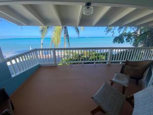 Un balcón con sillas y vistas al océano. en Tranquil Beachfront Duplex-type Private House!, en Hauula