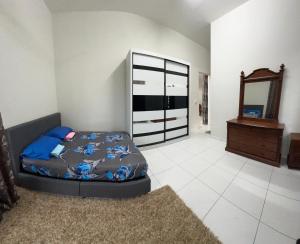 Un dormitorio con una cama, una cómoda y un espejo. en Dhuha Homestay, en Kampong Kerubong