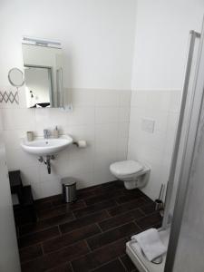 a bathroom with a sink and a toilet and a mirror at Gästehaus bed & kitchen in Schleswig