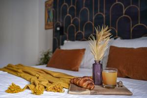 a tray with a glass of orange juice and pastries on a bed at Depero di TSS' - Chic, Appena Rinnovato vicino al MART, Supermercato, Ristoranti in Rovereto