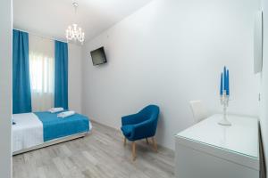 a bedroom with a bed and a blue chair at Villa Lux in Trogir