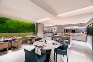 a restaurant with tables and chairs and a kitchen at Intercity Yangzhou Slender West Lake in Yangzhou