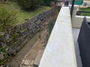 a retaining wall next to a stone wall at Chez Jean Marc et Corinne in Priay
