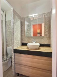 La salle de bains est pourvue d'un lavabo et d'un miroir. dans l'établissement Petit cocon, à Saint-Avold