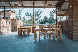 a group of wooden tables and chairs under a pavilion at Rafiki Retreat in Arusha