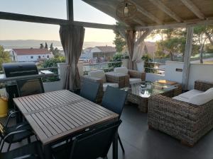 een patio met een tafel en stoelen op een balkon bij Apartman Luna in Sveti Filip i Jakov