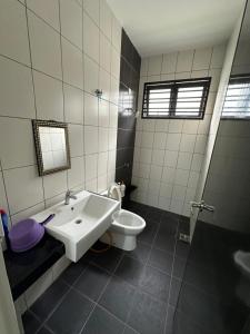 Un baño con un lavabo blanco y un inodoro. en Dhuha Homestay, en Kampong Kerubong 30 fotos más