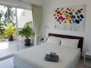 a bedroom with a bed with a bow on it at Beachside 3-Bedroom Townhouse w Private Pool at 70 Meters from Beach in Ban Bang Po