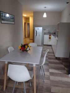 cocina con mesa blanca y sillas blancas en Depto cerca de Palmares Shopping Mall, en Godoy Cruz