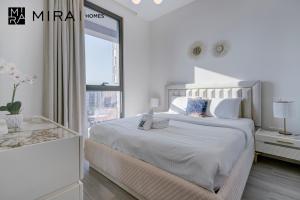 ein weißes Schlafzimmer mit einem Bett und einem Laptop darauf in der Unterkunft Mira Holiday Homes - Lovely 1 bedroom in Midtown in Dubai