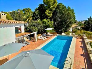 a villa with a swimming pool with umbrellas at Modern private Suite at fantastic villa near Fuengirola in Mijas