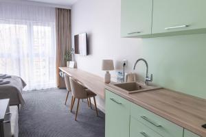 uma cozinha com um balcão, um lavatório e uma cama em Apartamenty Wolności 6 self check-in 24h em Poznań