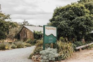 um sinal no meio de uma estrada com um edifício em Skillogalee Estate em Clare