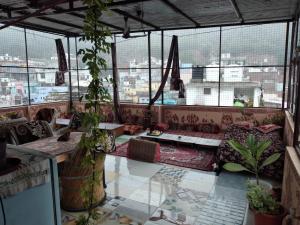 a room with a couch and a table and windows at RINGOSTAR PAYING GUEST HOUSE & ROOF TOP RESTAURENT in Būndi