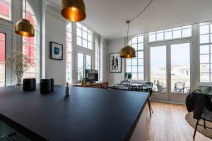 a living room with a large black table and windows at BLUE MOON KEYWEEK Seafront Apt with large Terrace and Parking Biarritz in Biarritz +11 photos