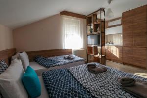 a bedroom with two beds with towels on them at Studio Apartments Maksimović in Niš