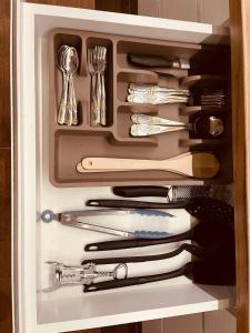 a drawer full of utensils in a cabinet at Apartman Delux in Bačka Topola