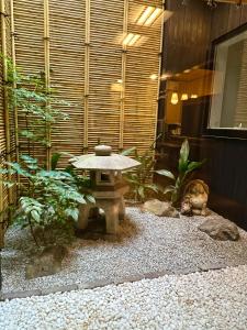 een kleine tuin met een stenen tafel in het midden bij Nishodo Machiya HIKARU GOJO in Kyoto