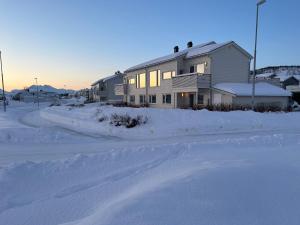 una casa nella neve con una strada davanti di Room in Tromsø, Kvaløya a Tromsø