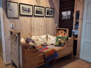 a wooden bed in a room with pictures on the wall at Granum Gård in Fluberg