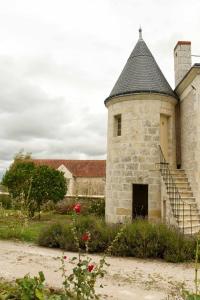 an old stone building with a staircase in a yard at The Plessis eco lodge at Port du Loup in Ferrière-Larçon