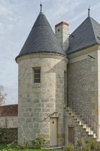 een oud bakstenen gebouw met een schoorsteen en een deur bij The Plessis eco lodge at Port du Loup in Ferrière-Larçon