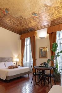 a bedroom with a bed and a table with chairs at Hotel Bologna in Turin