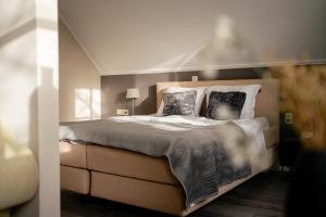 ein Schlafzimmer mit einem großen Bett mit zwei Kissen in der Unterkunft De Postelhoek B&B in Oud-Ootmarsum