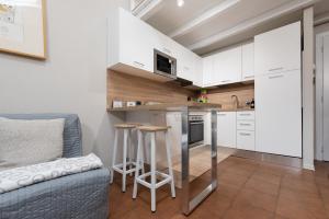 eine kleine Küche mit weißen Schränken und einer blauen Couch in der Unterkunft La Casetta di Tiffi - Borgo Lovere in Lovere