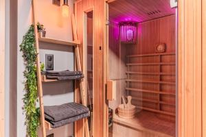 una cabina armadio con ripiani in legno e illuminazione viola di Loft sous les colombages d'Alsace / Sauna / Jacuzzi / Netflix / Wifi a Drusenheim