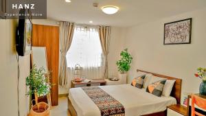 een slaapkamer met een bed en een raam bij HANZ The Galaxy Hotel in Ho Chi Minh-stad