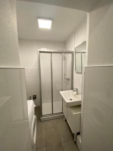 un bagno con doccia, WC e lavandino di ZUR SCHLEUSE - Ferienwohnung bis 6 Personen mit gem Garten a Rostock