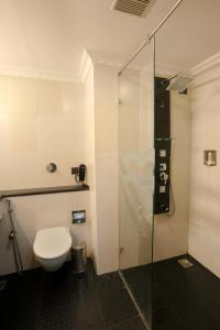a bathroom with a toilet and a glass shower at Blue Waters Cherai in Cherai Beach