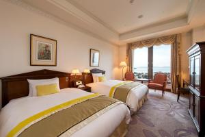 a hotel room with two beds and a window at Hotel Okura JR Huis Ten Bosch in Sasebo