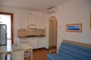 cocina con sofá y mesa en una habitación en Villaggio Capistrano, en Bibione